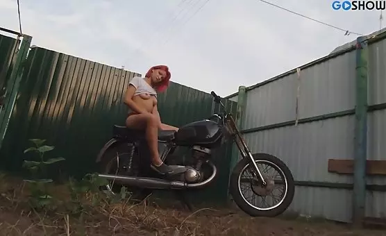 Sensual motorcycle goddess luring outdoors